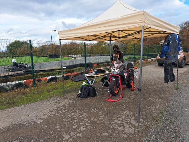 Team set up under a gazebo alongside a karting track.